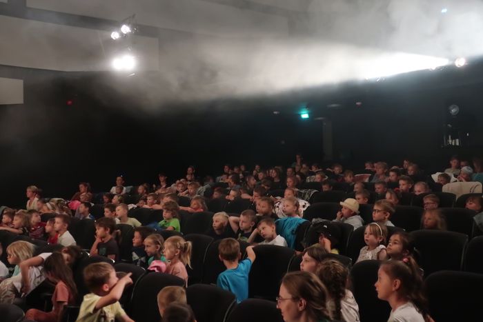 Dzieci siedzą na widowi w teatrze