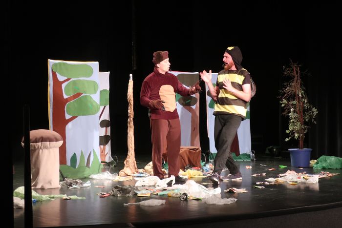 Aktorzy przebrani za misia i pszczołę na scenie teatralnej