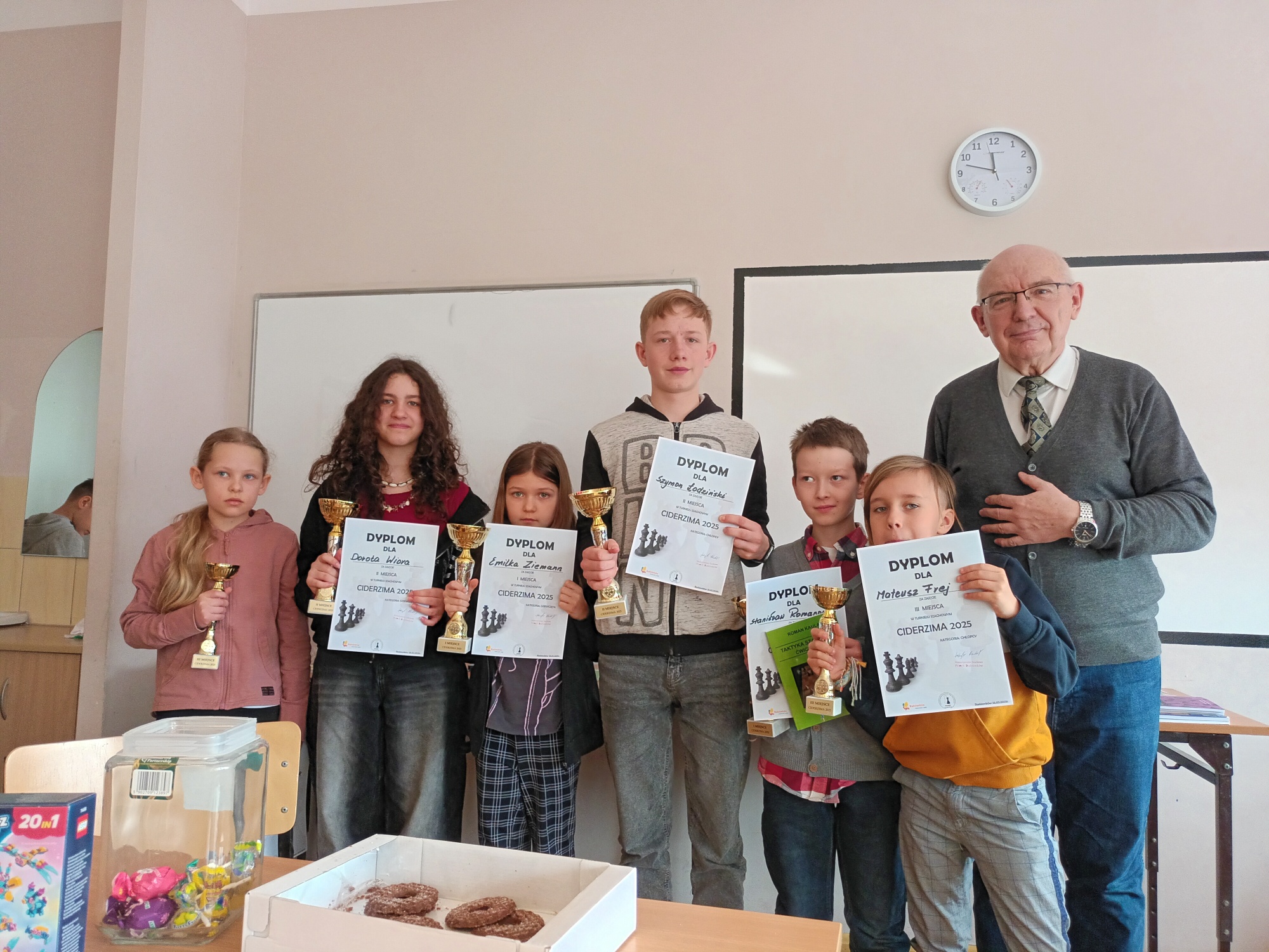 Cała grupa zwycięzców trzymających nagrody wraz z nauczycielem