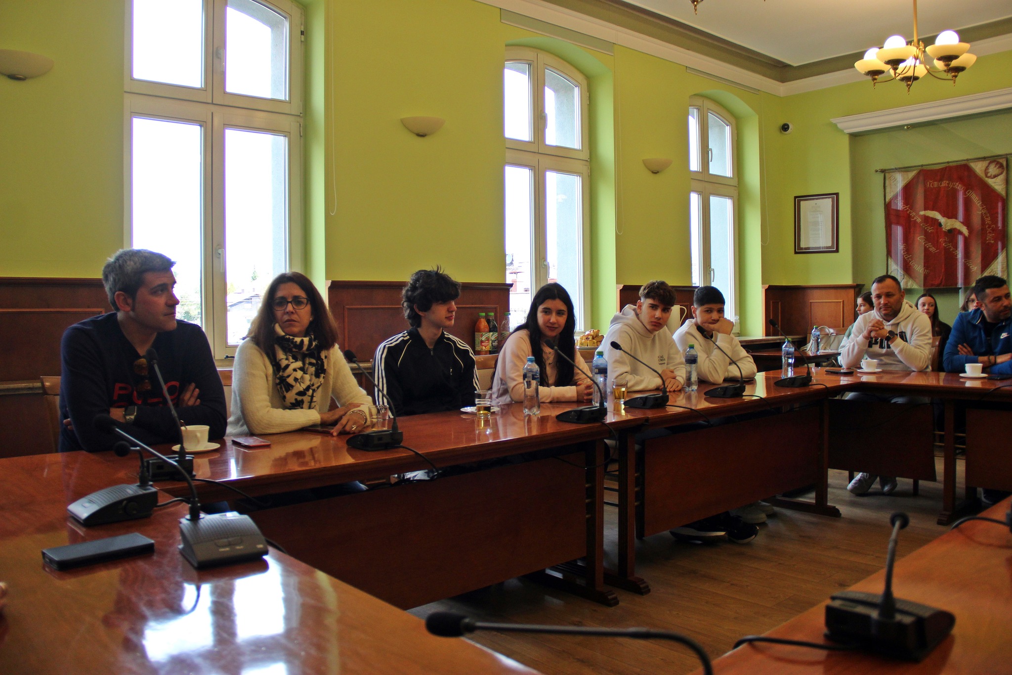 Młodzież z programu Erasmus+ siedzą na spotkaniu w Urzędzie Miasta.