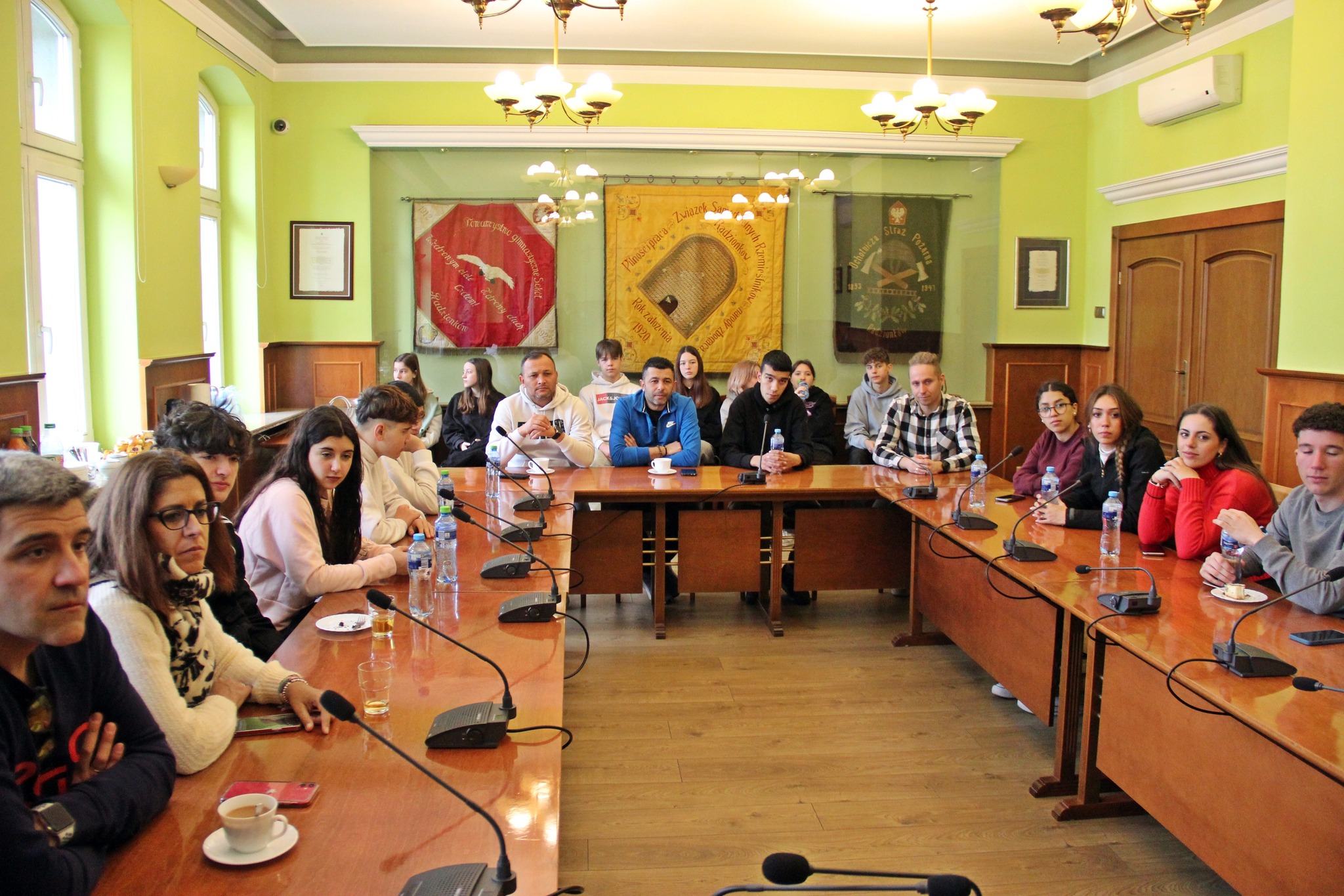 Młodzież z programu Erasmus+ siedzi na spotkaniu w Urzędzie Miasta.