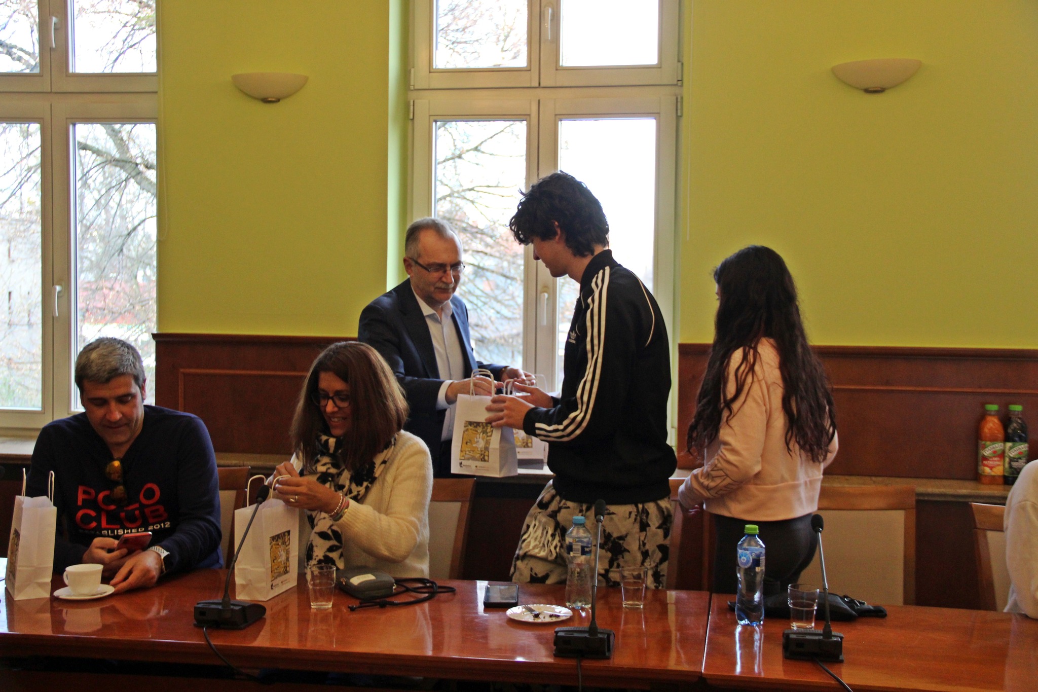 Przedstawiciel miasta przekazuje upominki młodzieży z programu Erasmus+.