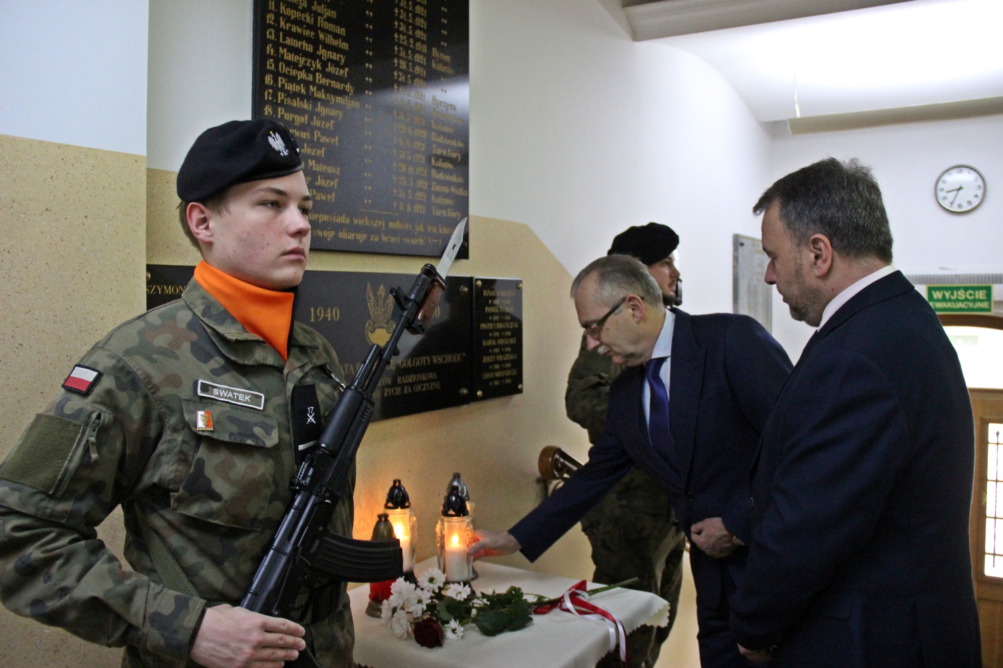 Składanie znicza przed tablicą upamiętniającą ofiary zbrodni katyńskiej.