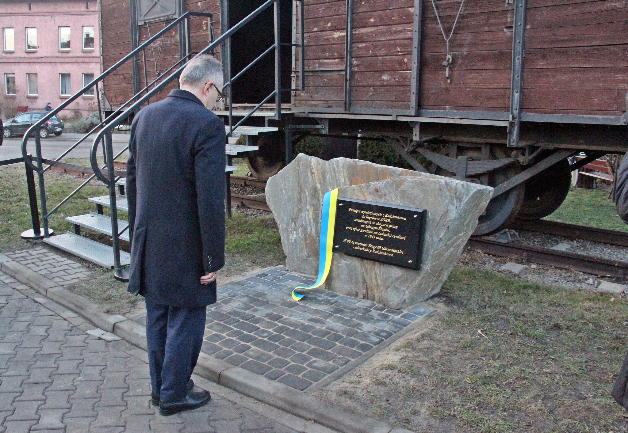 Przedstawiciel urzędu oddaje hołd przed tablicą pamiątkową
