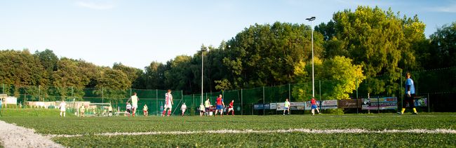 Młodzież gra w piłkę nożną na boisku