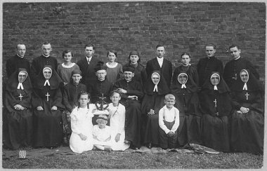 Ludwik Wrodarczyk z grupą księży, sióstr zakonnych i rodzin z dziećmi