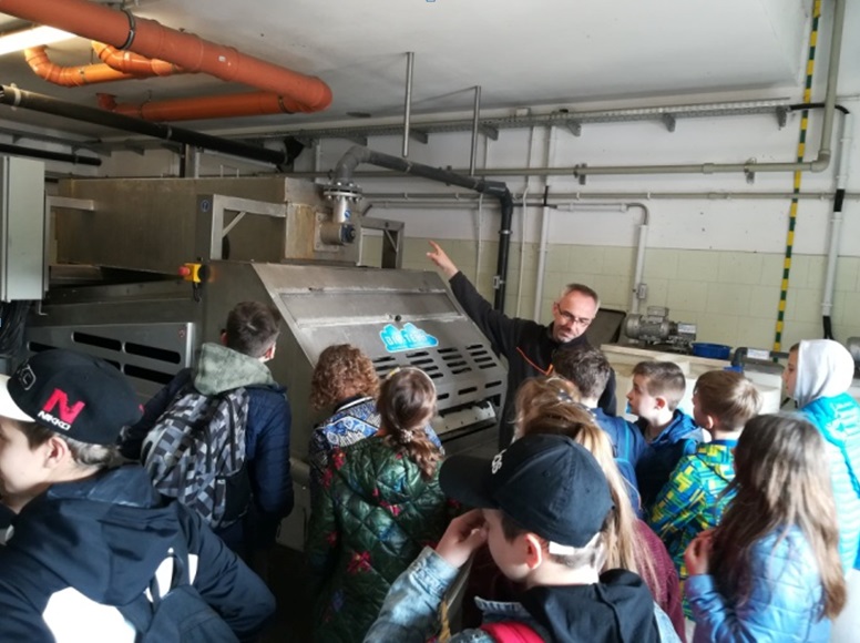 Pan pokazuje młodzieży jakąś maszynę